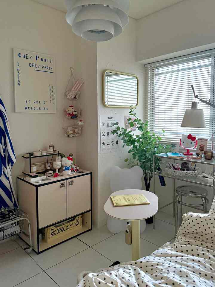 White and ivory toned small compact studio apartment featuring modern minimalist furniture and a plant near the window