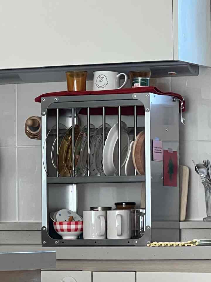 ホワイトとグレーのトーンのキッチン、304ステンレスのモダンキッチンラックに皿とマグカップが整理された清潔な空間