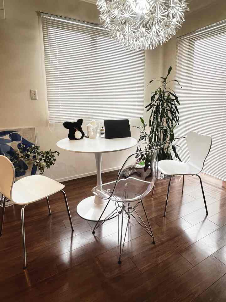 White and wood tone dining room featuring a round dining table with chairs in a clean, natural setting