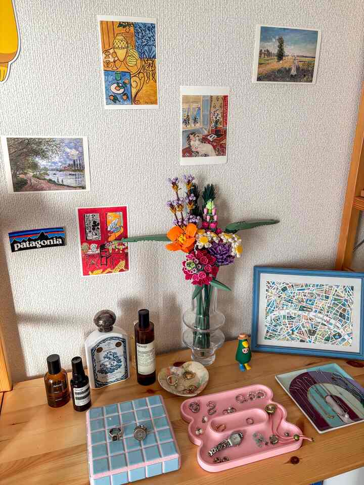 木目調のテーブル上に多彩な花瓶とアクセサリーが配置された雰囲気のあるインテリア空間