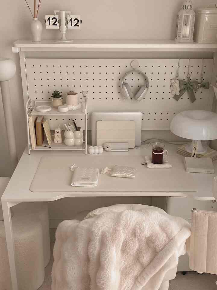 白とベージュの色調のホームオフィス、シンプルモダンなデスクと収納棚、照明が配された雰囲気のあるインテリア