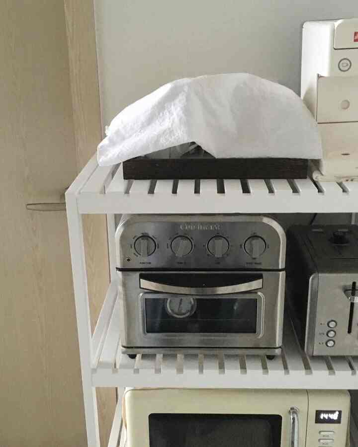 白いメタル棚にレトロな電子レンジとステンレス製トースターが置かれたキッチンのインテリア