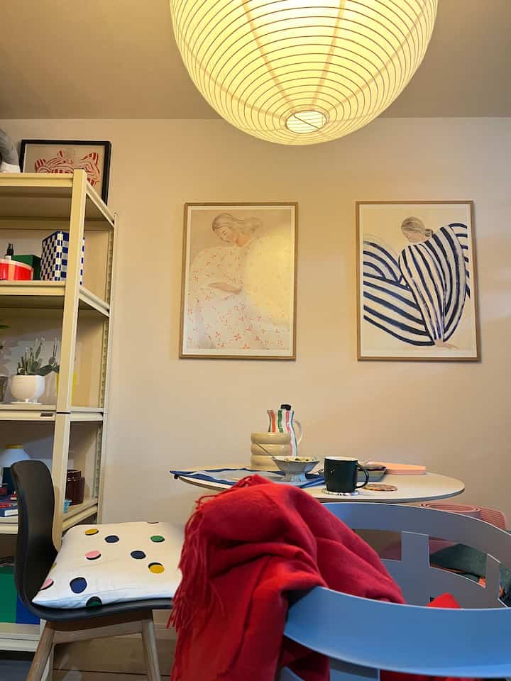 暖かい照明の下、白い壁とライトグレーの家具が配置されたミッドセンチュリーモダンの印象的なダイニングルーム