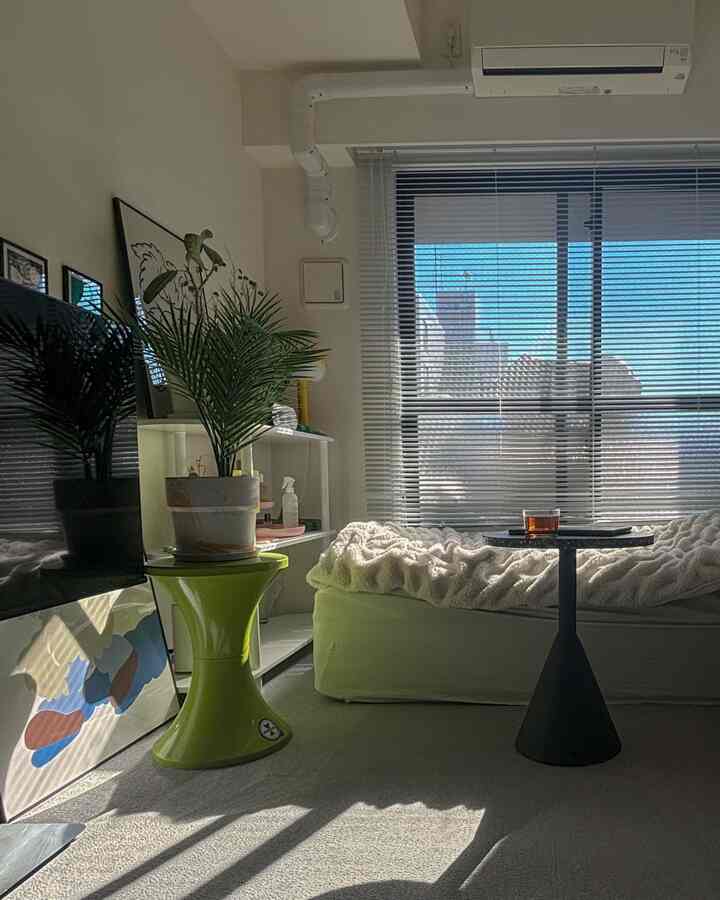 Natural-toned 8-tatami bedroom featuring side tables and a plant with blinds filtering daylight, cozy single household space