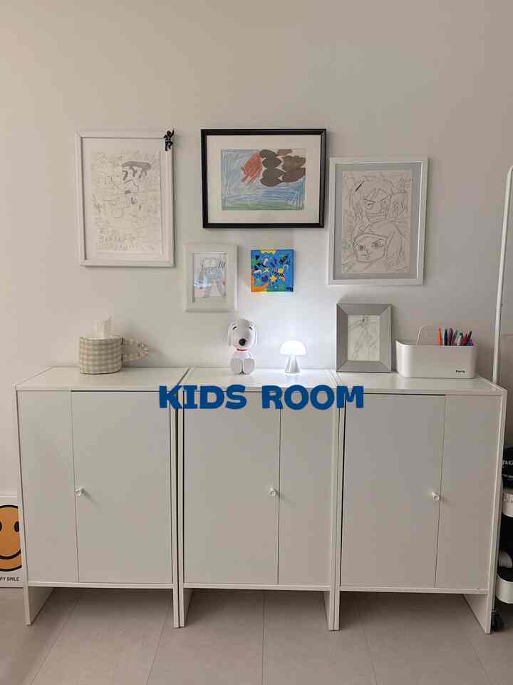白を基調とした子供部屋、イケアのキャビネットと子供の絵が飾られた印象的なインテリア