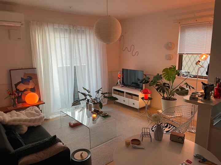 柔らかなホワイトと木目調のリビング、ミッドセンチュリーモダン家具と多彩な間接照明が調和する雰囲気のある空間