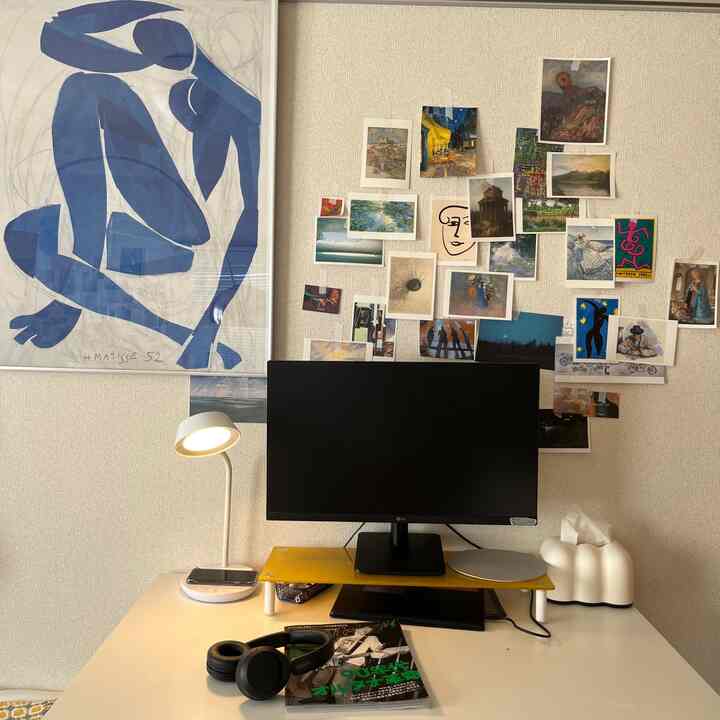 White-walled 8-tatami studio home office with yellow monitor stand, featuring various art prints creating an artistic atmosphere