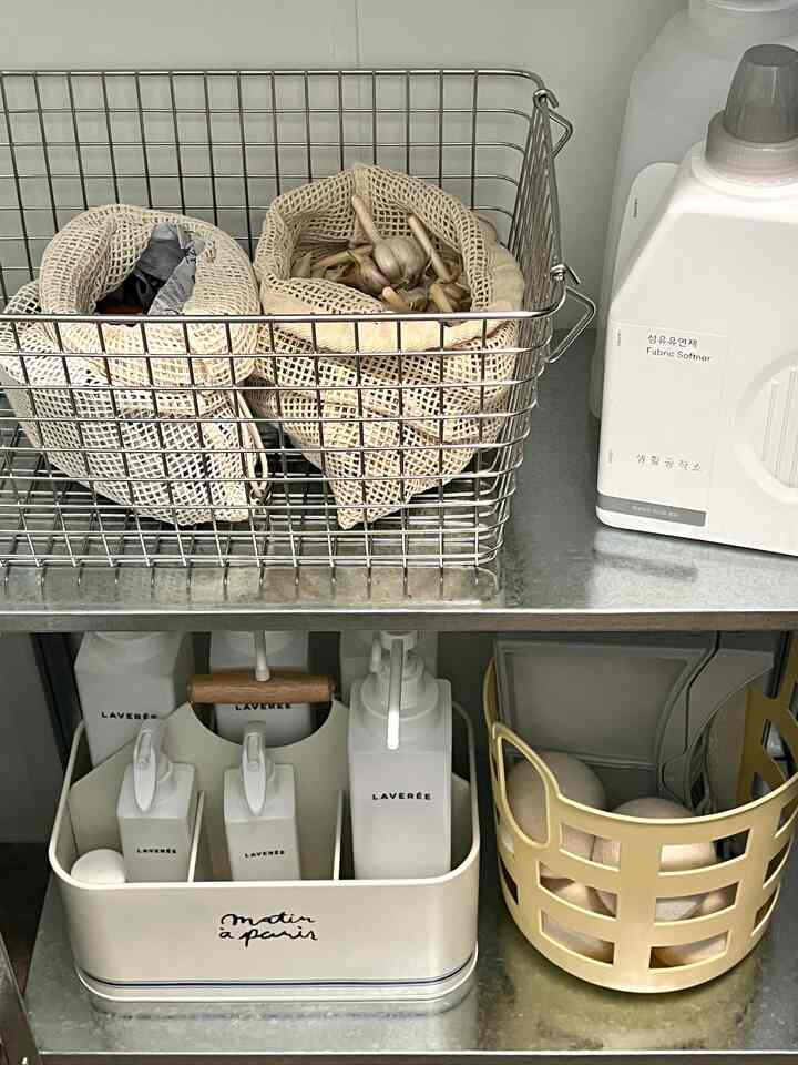 シルバー調のパントリー収納スペース、ステンレスのワイヤーバスケットと整然とした容器が配置された雰囲気のあるインテリア