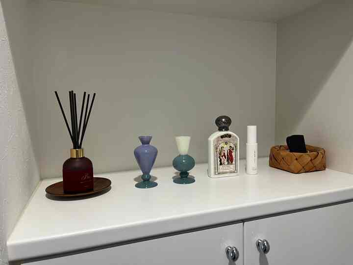 ホワイトと木目調が調和した玄関の棚、様々な装飾雑貨が配置された落ち着いた雰囲気のあるインテリア