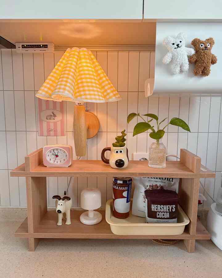 A clean kitchen space with a yellow checkered table lamp and wooden shelf organizer