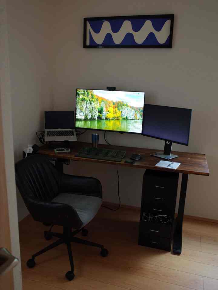 木目調の床と黒いデスク、椅子がある6畳のモダンなホームオフィス空間