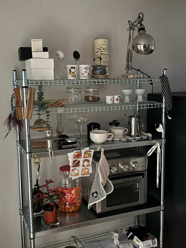 シルバーのイケアスチール棚にキッチン用品とカップが置かれたミニマルなキッチンの雰囲気のあるインテリア