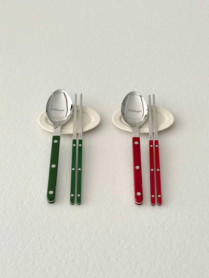 Image of Sabre chopsticks and spoons with green and red handles neatly arranged on a white background