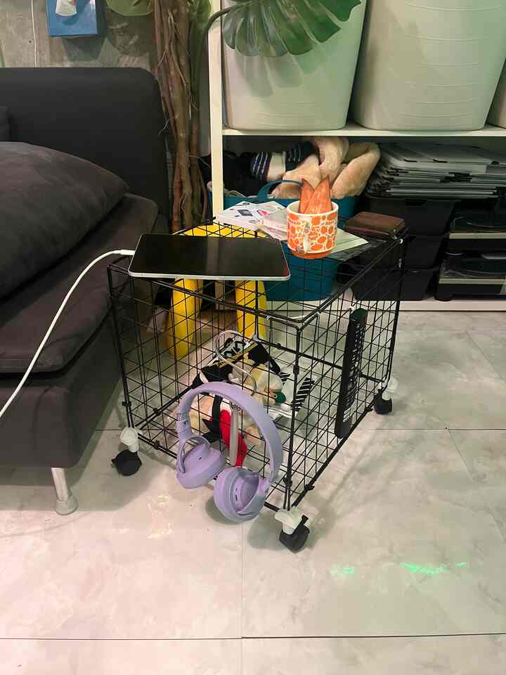 黒のワイヤーバスケットにキャスターが付いた多機能家具が配置されたコンパクトな一人暮らしのワンルーム