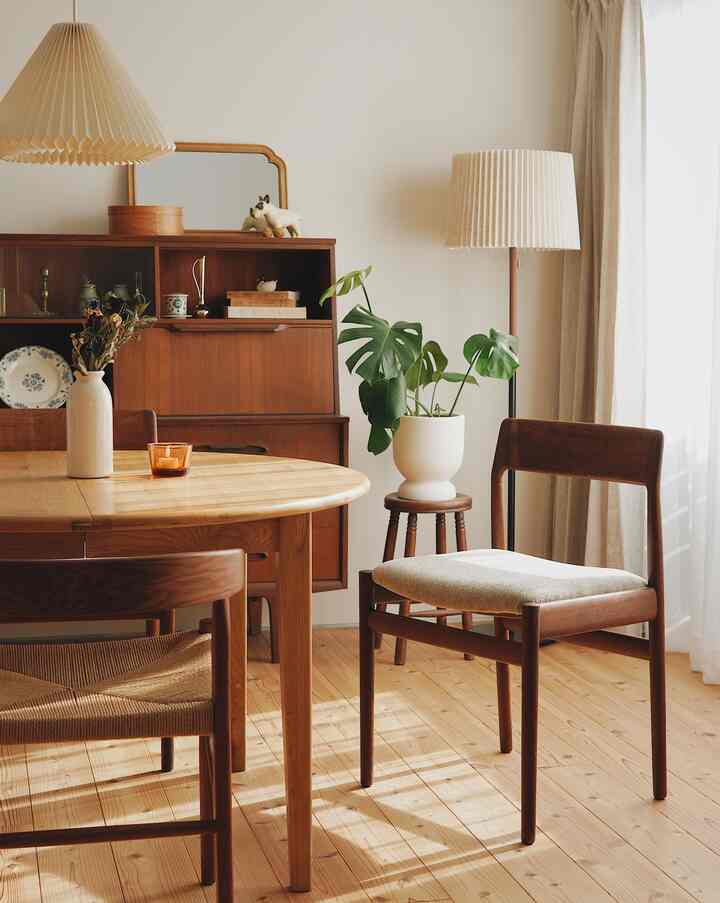 Dining room with natural wood tones and beige accents featuring a wooden dining table and vintage dining chairs, creating a warm atmosphere