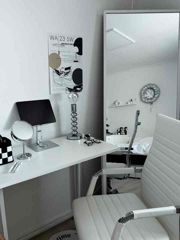 Monotone white and gray bedroom featuring a desk and office chair with a clean modern workspace setup