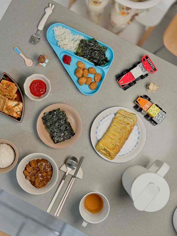 #오홈스토랑 #콘수프기록 

子供と一緒にするご飯はいつも特別ですね！ 💛

今日は子供が好きなメニューで準備した一賞です。 
キンバプ、卵が、ミニナゲットまで子供が好きなメニューでいっぱい詰めました。
一方ではレゴのおもちゃも食卓の上に位置していますね。
ご飯を食べながらも遊びを逃さない子供の想像力に笑いがあります。 😊

こうして子供との食事は単純なキニを越えて思い出になり、遊びになって特別になるようです。 

様々なお皿や可愛い幼児食器まで加えられ、さらに赤ちゃんの感じ！子どもが快適にご飯を食べ、
面白い時間を過ごす様子を見ると、親としても心が暖かくなりますね。 🥰  #레고놀이 #유아식기 #아이와놀이 #홈스타일링 #유아식단 #일상스타그램 #계란말이 #아이밥상 #아이밥상차리기 #엄마의정성 #집밥그램 #간단레시피 #육아일상 #소소한행복 #밥상스타그램 #놀이와식사 #우리집테이블 #행복한식사 