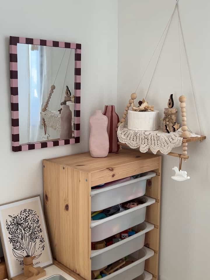 ナチュラルな木目調の子供部屋、収納棚と装飾された額縁が温かみのある雰囲気のあるインテリア