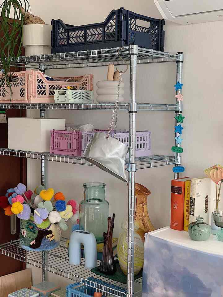 Silver-toned living room featuring a metal rack with colorful crates and decorative items creating a cozy atmosphere