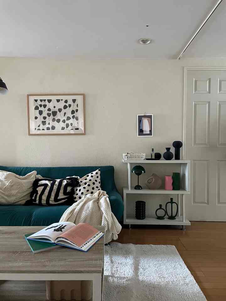 白とモノトーンの背景に緑のソファとコーヒーテーブル、北欧スタイルのリビングが落ち着いた雰囲気を醸し出すインテリア