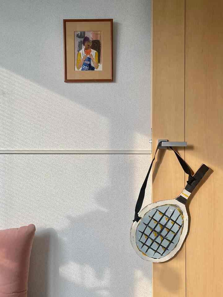 Beige-toned entrance space featuring a wooden door and framed art on the wall, creating a natural atmosphere
