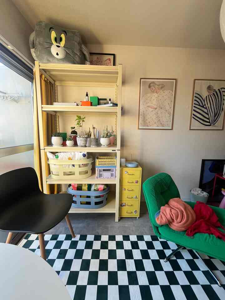 白い壁と多目的棚が配置され、小さな植物や収納バスケットが置かれたナチュラルで北欧風のインテリア