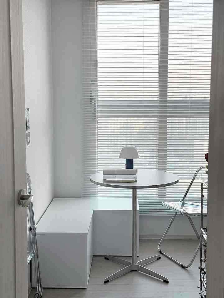 ホワイトと透明感のある素材で構成された狭くコンパクトな一人暮らし用ホームオフィス空間