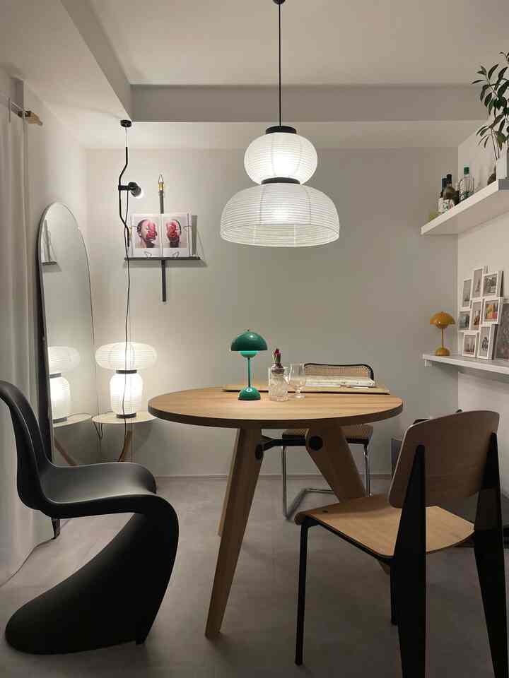 Minimal modern dining room with white walls and a natural brown round dining table