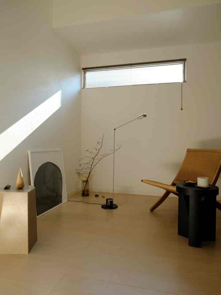 Bright beige-toned minimal living room with natural light, featuring a paper cord armchair and floor lamp