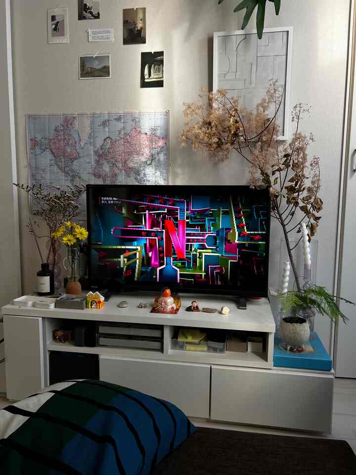 白を基調としたリビング、テレビ台とポスター、植物が配置されたシンプルでナチュラルなインテリア