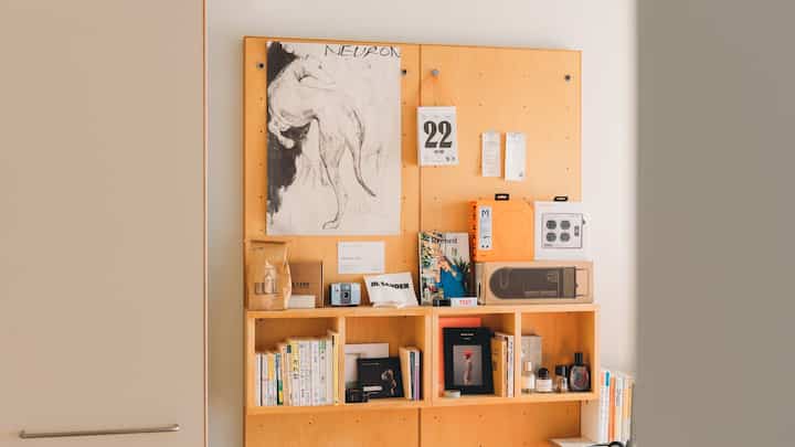 Natural-toned study space featuring wooden bookshelf and posters with clean decor