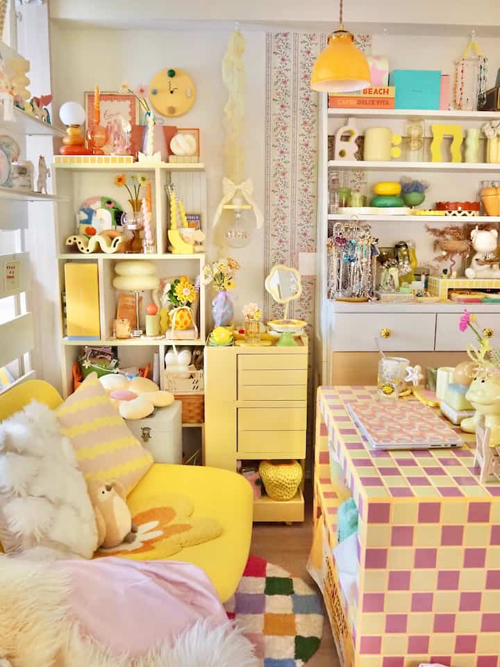 明るくカラフルな黄色調のリビング、かわいらしい小物と収納棚が配された雰囲気のあるインテリア