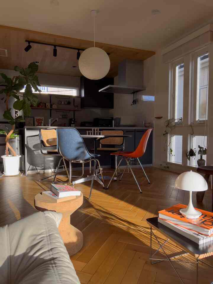 Wood tone and white kitchen and dining room featuring mid-century modern chairs and round dining table in a cozy setting