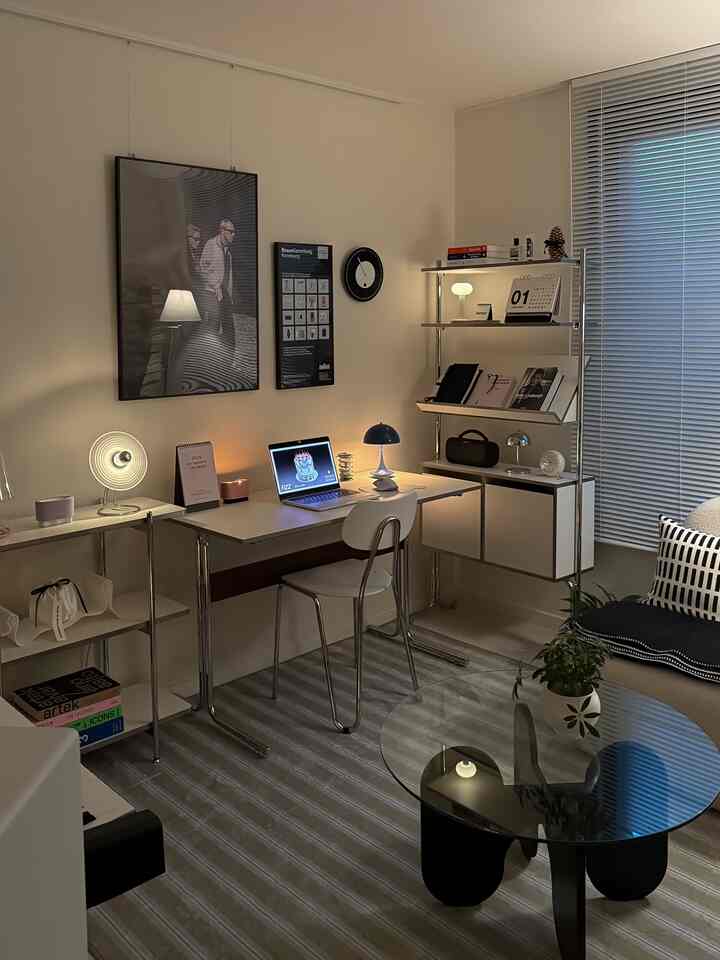 白を基調としたホームオフィス空間で、机、椅子、本棚、ソファ、ラグが配置されたモダンで清潔感のあるインテリア