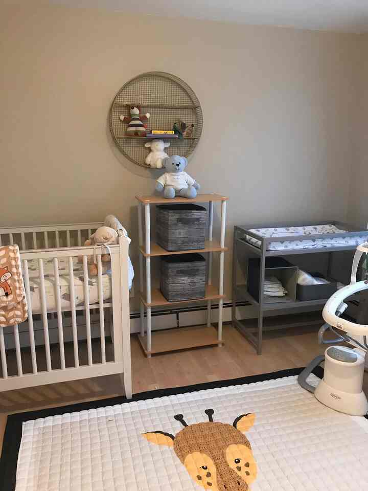 Beige-toned walls and natural wood furniture in a nursery featuring a crib and changing table, creating a warm and cozy atmosphere