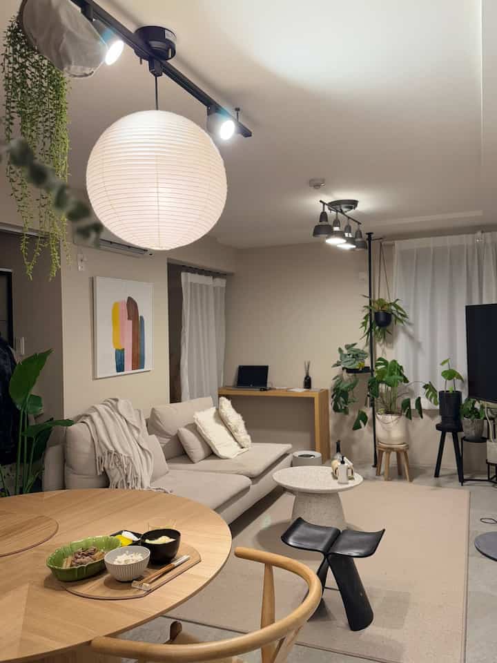 Beige-toned 2LDK living room featuring a 3-seater sofa, round dining table, and Japanese-style pendant light in a Wa-Modern style