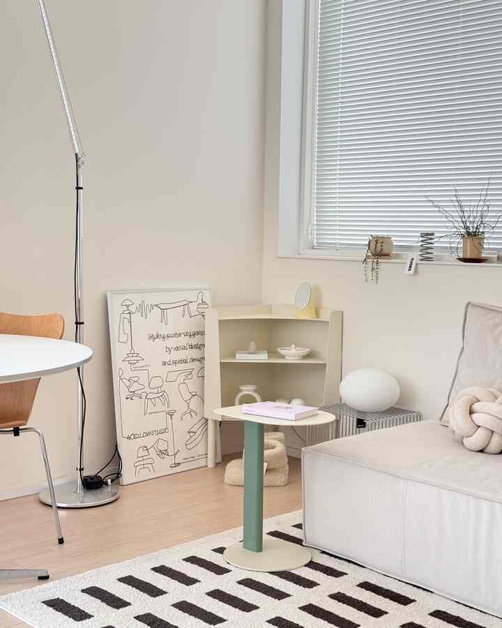 明るいホワイトとベージュの色調のリビング、快適なソファとサイドテーブル、コーナーシェルフが配された雰囲気のあるナチュラルモダンなインテリア