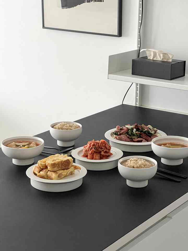 白い食器と黒いテーブルが配されたモダンなキッチンのシンプルな食卓のインテリア