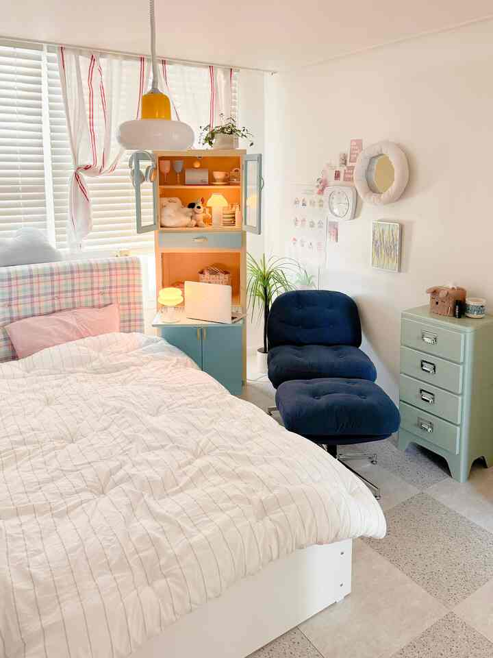 Pastel and natural color toned 6 tatami bedroom featuring a bed, nightstand, and blue armchair creating a cozy atmosphere