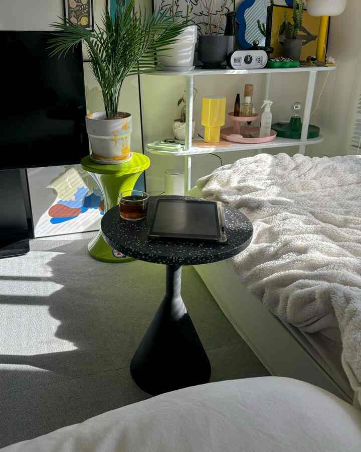 Natural color toned 8-tatami bedroom featuring a black side table next to bed with cozy blanket and green plants