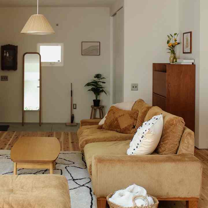 ナチュラルカラーのリビング、ベージュのソファと木製のコーヒーテーブルが配置された雰囲気のある空間