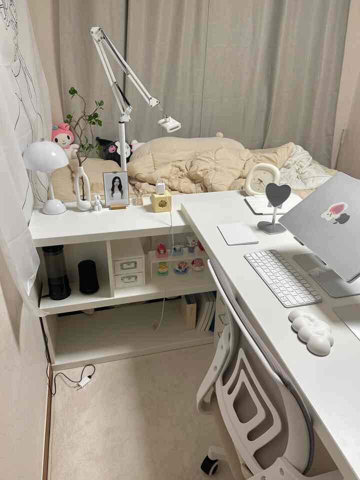 ホワイトとベージュの色調で、狭い寝室にデスクとベッドが配置されたシンプルな一人暮らしの空間