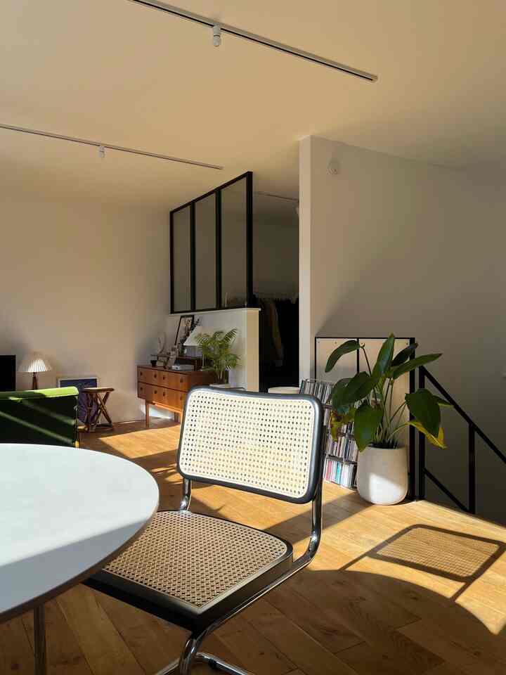 暖かい木目調と黒のフレームが調和したナチュラルヴィンテージのリビング、チェスカチェアとチェストが配置されています。