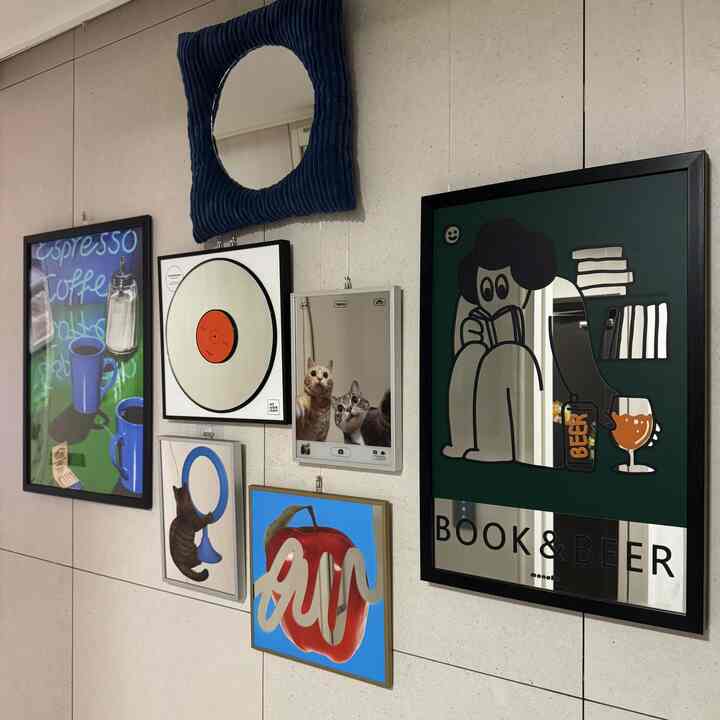 ネイビーを基調としたポスターと鏡が配置された廊下のギャラリーウォール、猫がいるアットホームなフォトゾーン
