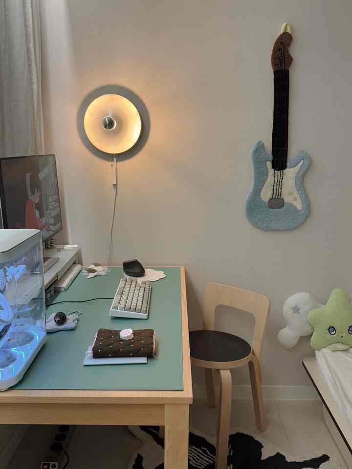 ホワイトとウッドトーンが調和した6畳の小さなホームオフィス、ミント色のデスクと壁照明が特徴的なシンプルモダンな空間