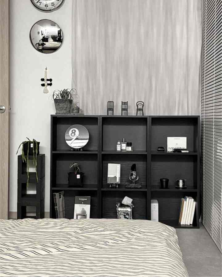 モノトーンの黒い棚と白いカーテンがあるシンプルな寝室インテリア