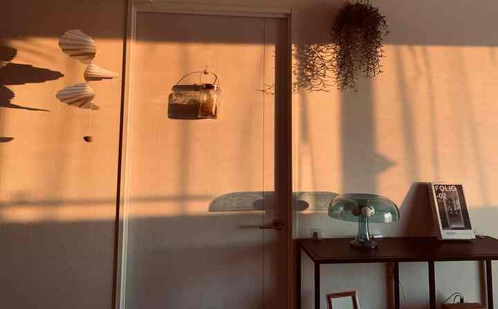 Warm beige-toned entrance space featuring a mushroom-shaped table lamp and wooden-textured table creating a cozy atmosphere