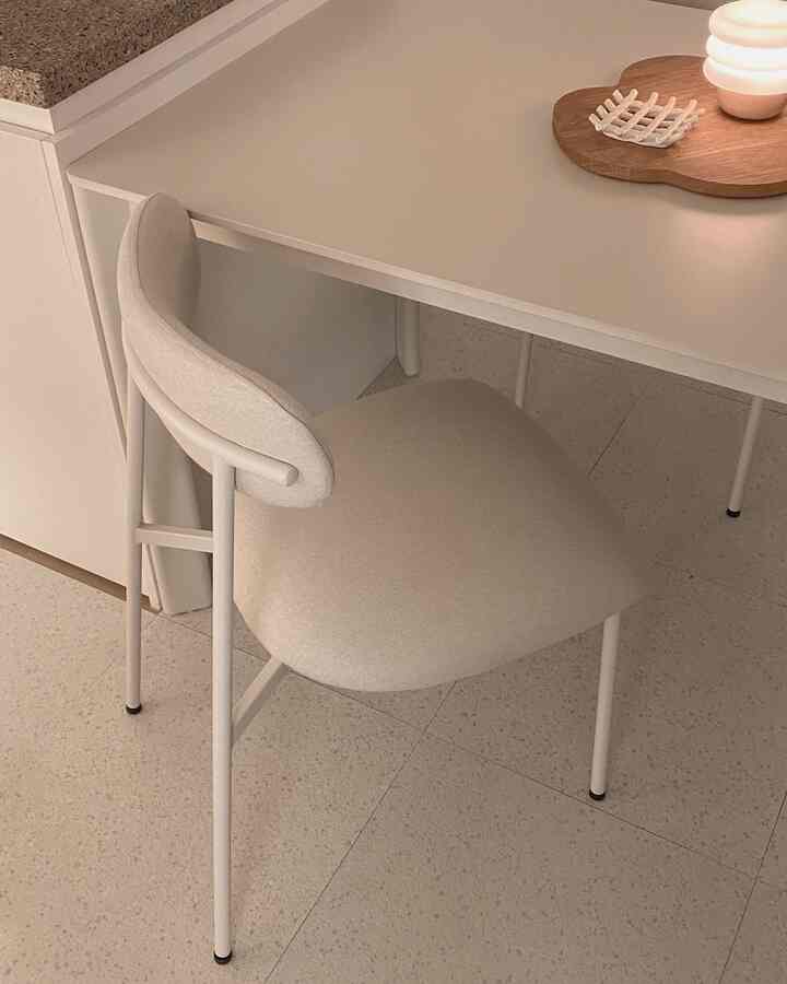 ナチュラルカラーのダイニング、クリーム色のラウンドチェアと白いテーブルが配置されたシンプルモダンな空間