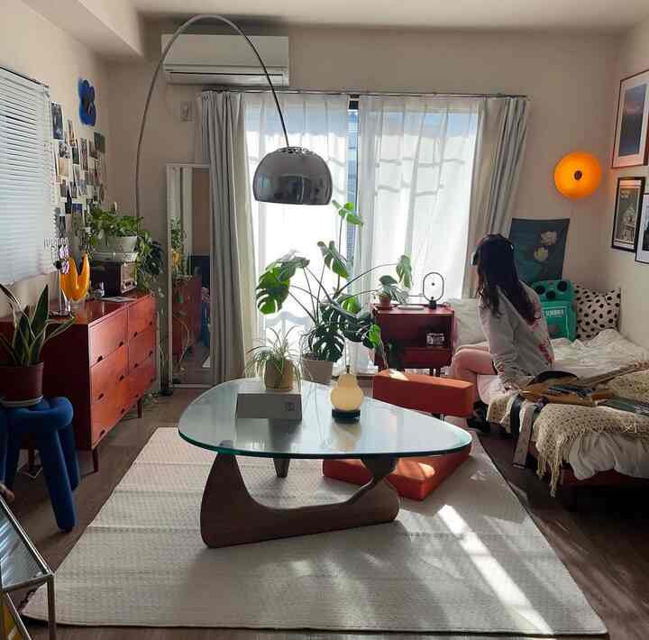 Natural wood tones and green plants in a cozy 8-tatami living-bedroom for single occupancy