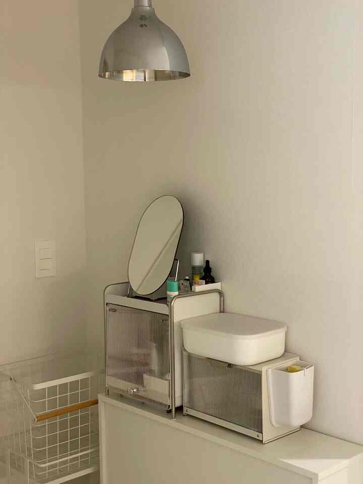 白を基調としたミニマルな収納スペースと化粧台が配置されたインテリア